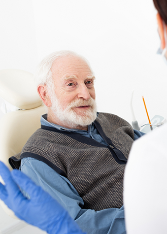 Senior man in the dental chair listening to his dentist