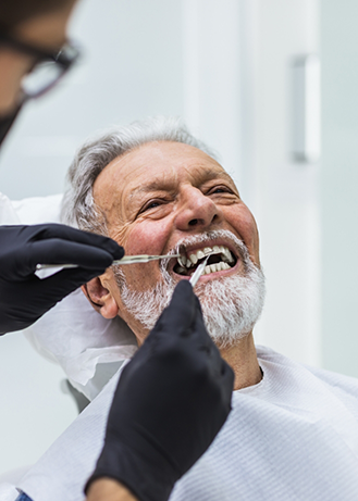 Senior man having his teeth examined by his dentist