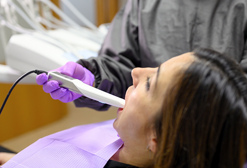 Dental patient getting her teeth digitally scanned by her dentist
