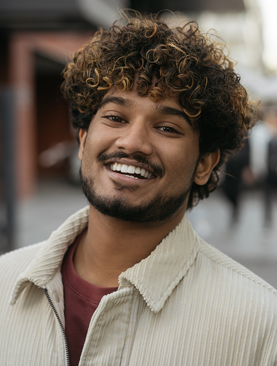 Smiling young man in an off white jacket