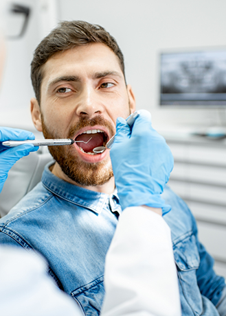 Man having his teeth examined by his dentist