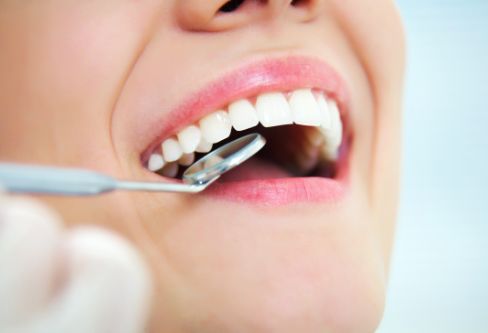 Close up of a dental mirror in a mouth